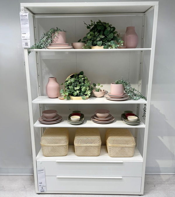 White shelf with light pink bowls, plates and pots with plants